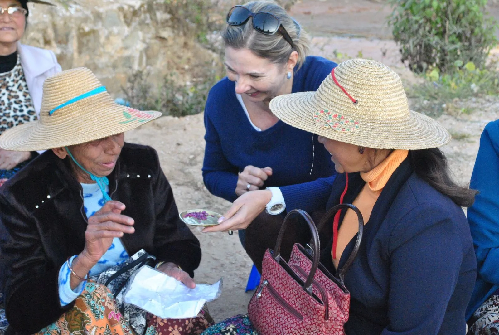 Looking at rough rubies with women from a mining village